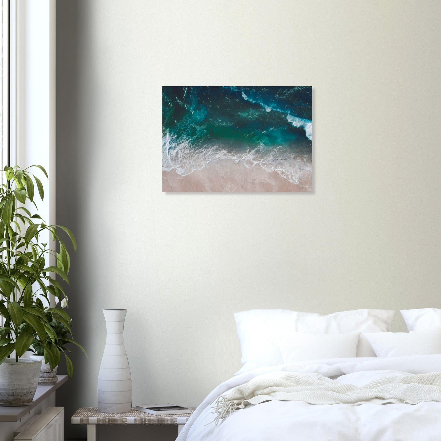 Aerial view of ocean waves rolling onto sand in teal and blue tones.