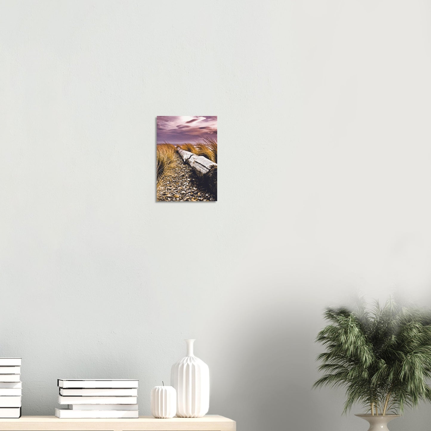 Driftwood lying in coastal grasses under a purple sky, evoking weathered texture and calm.