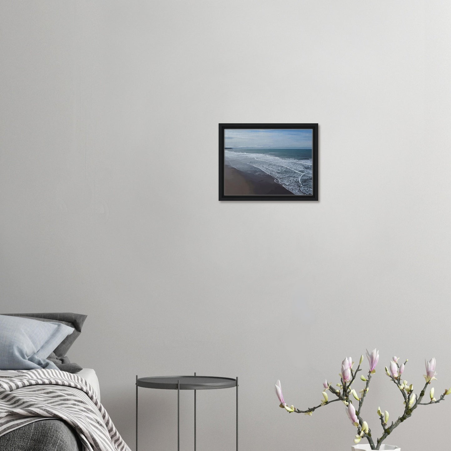 Soft, muted tones of sand, seafoam, and sky blend together in a calming composition, highlighting the natural rhythm of waves lapping the shore.