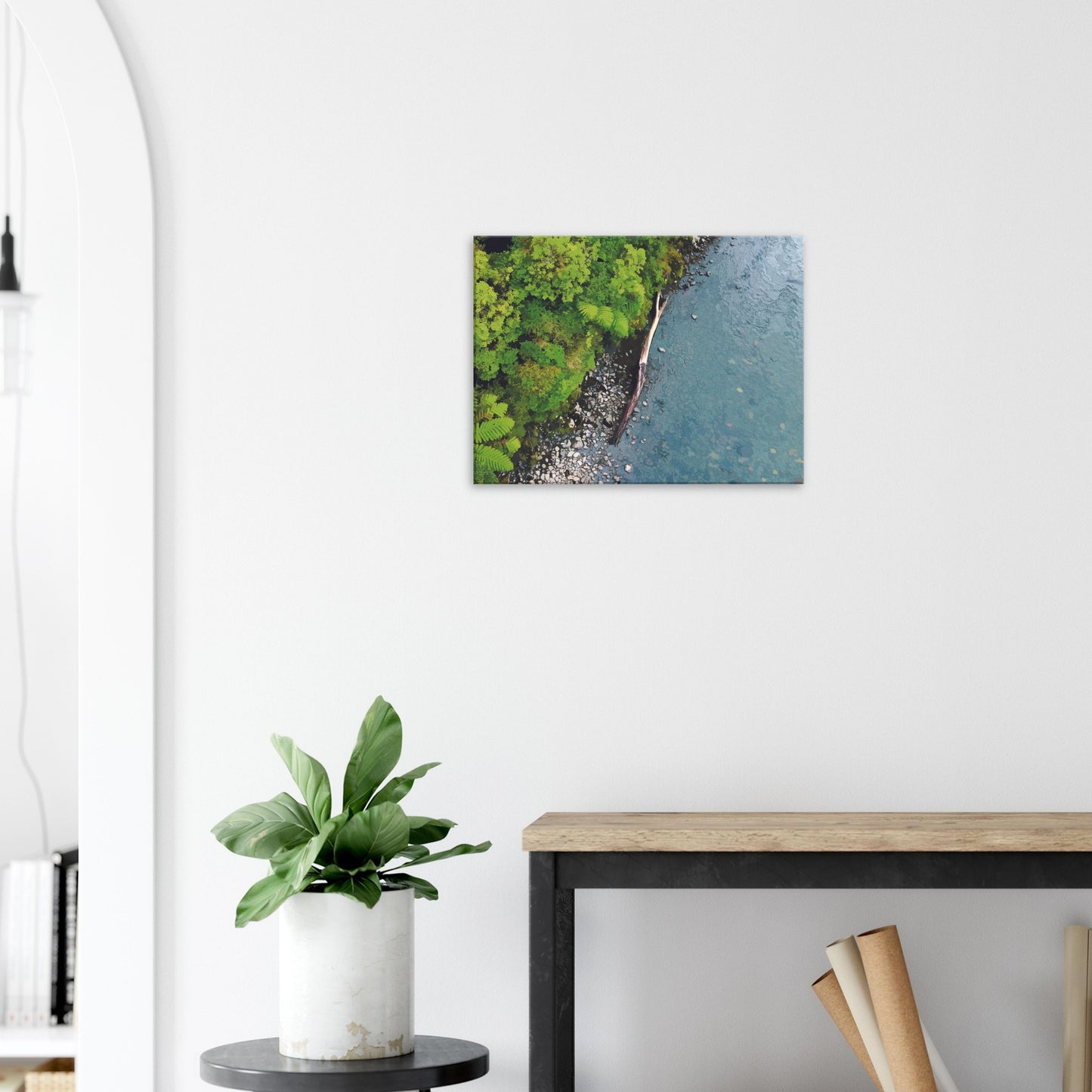 Artwork of native bush and a riverbank viewed from above, with driftwood resting at the water’s edge.