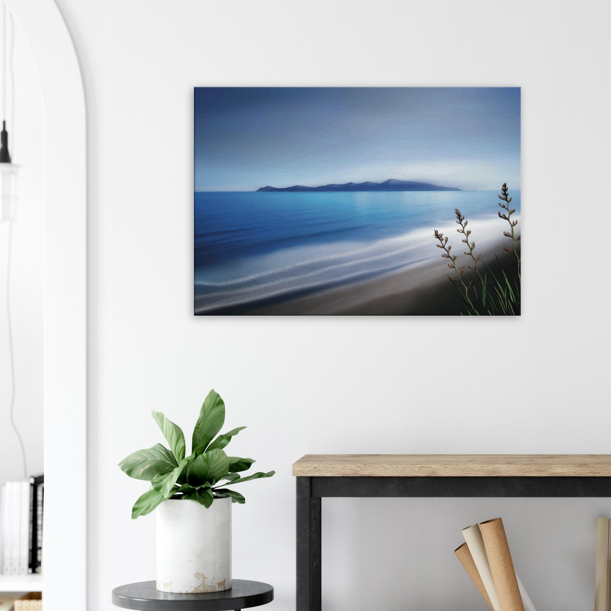 Kapiti Island with soft blue sea, gentle waves and native flax in the foreground.