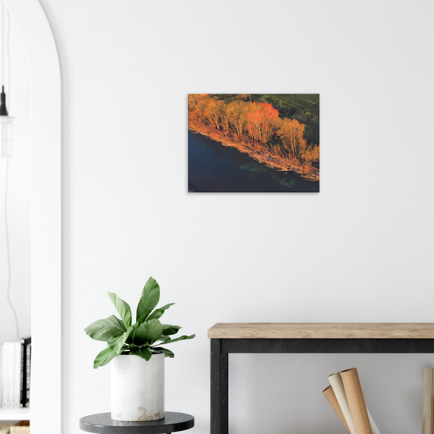 Aerial artwork of autumn trees glowing orange beside a deep blue New Zealand river, full of bold contrast and colour.