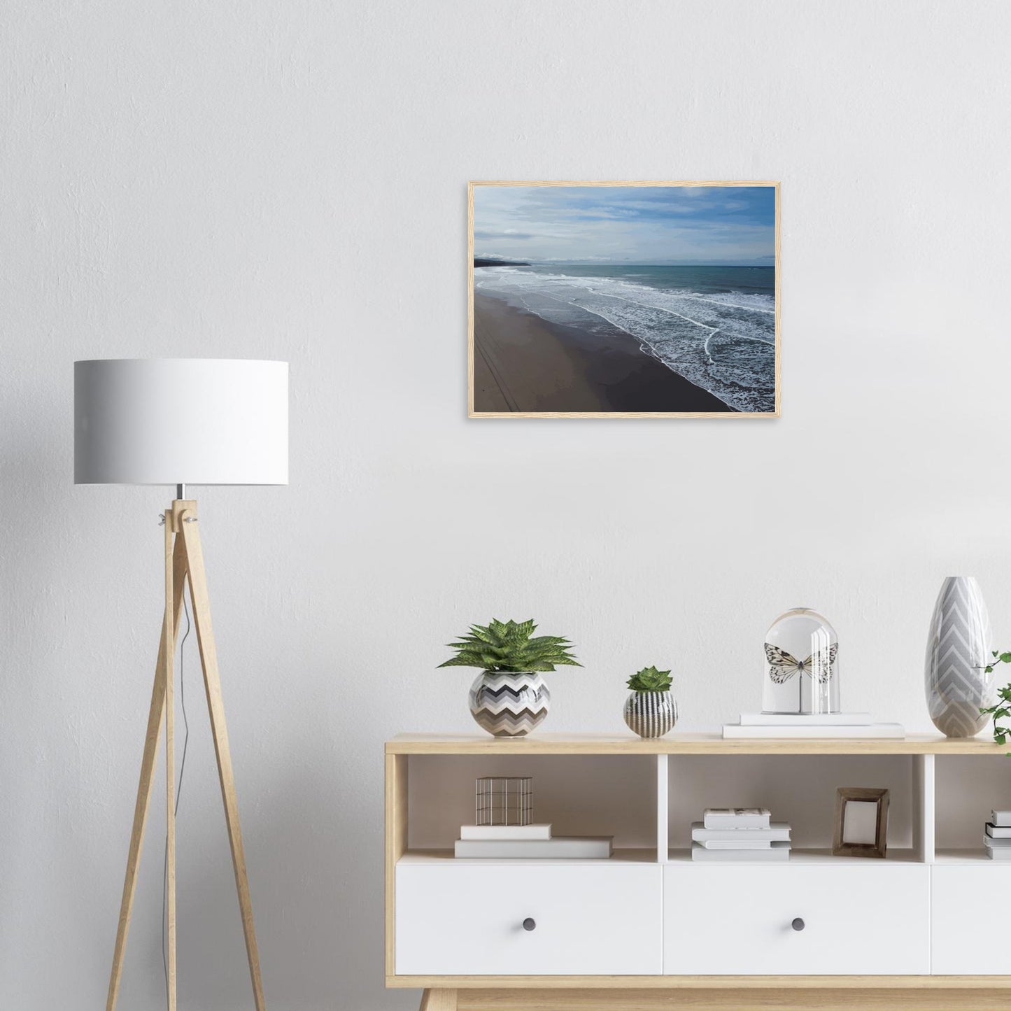 Soft, muted tones of sand, seafoam, and sky blend together in a calming composition, highlighting the natural rhythm of waves lapping the shore.