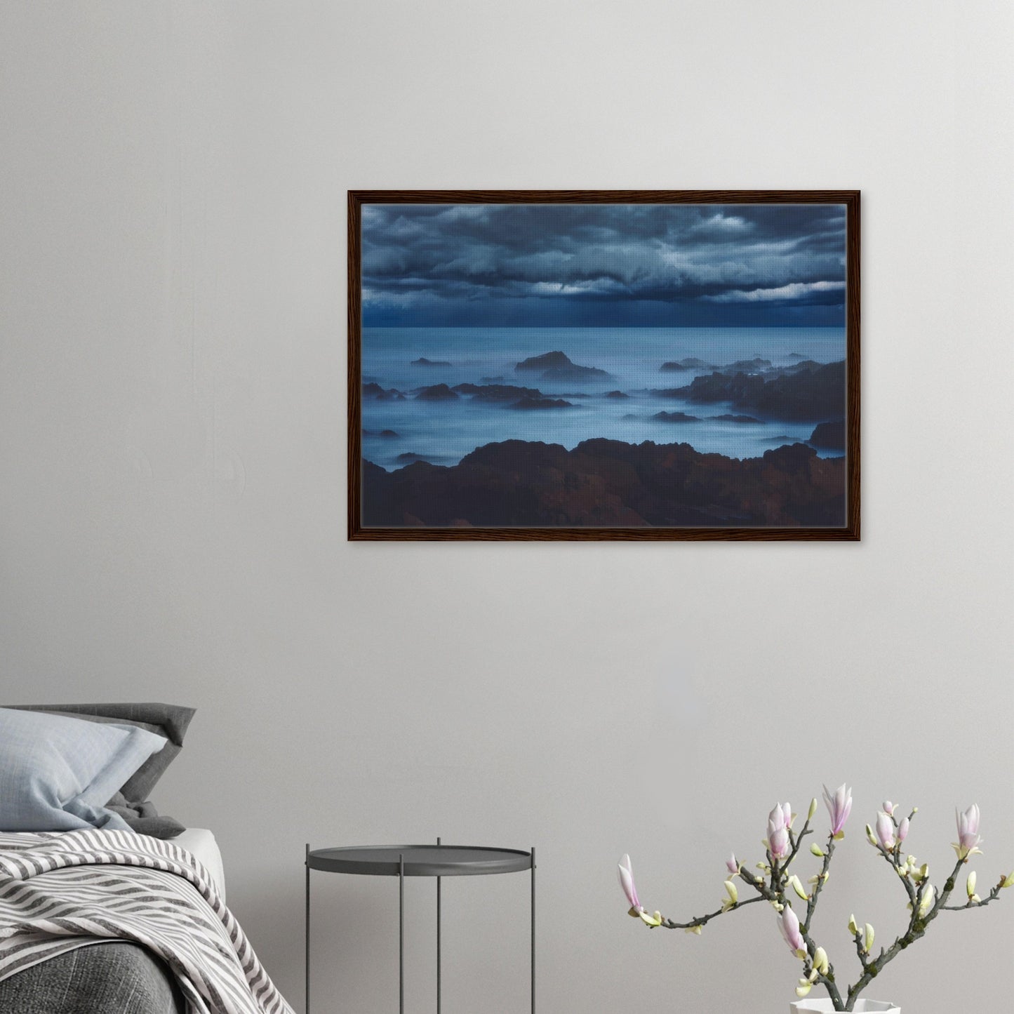 Deep navy and steel-blue tones sweep across a moody sky, while waves crash and swirl around jagged rocks, softened by a misty, dreamlike haze.