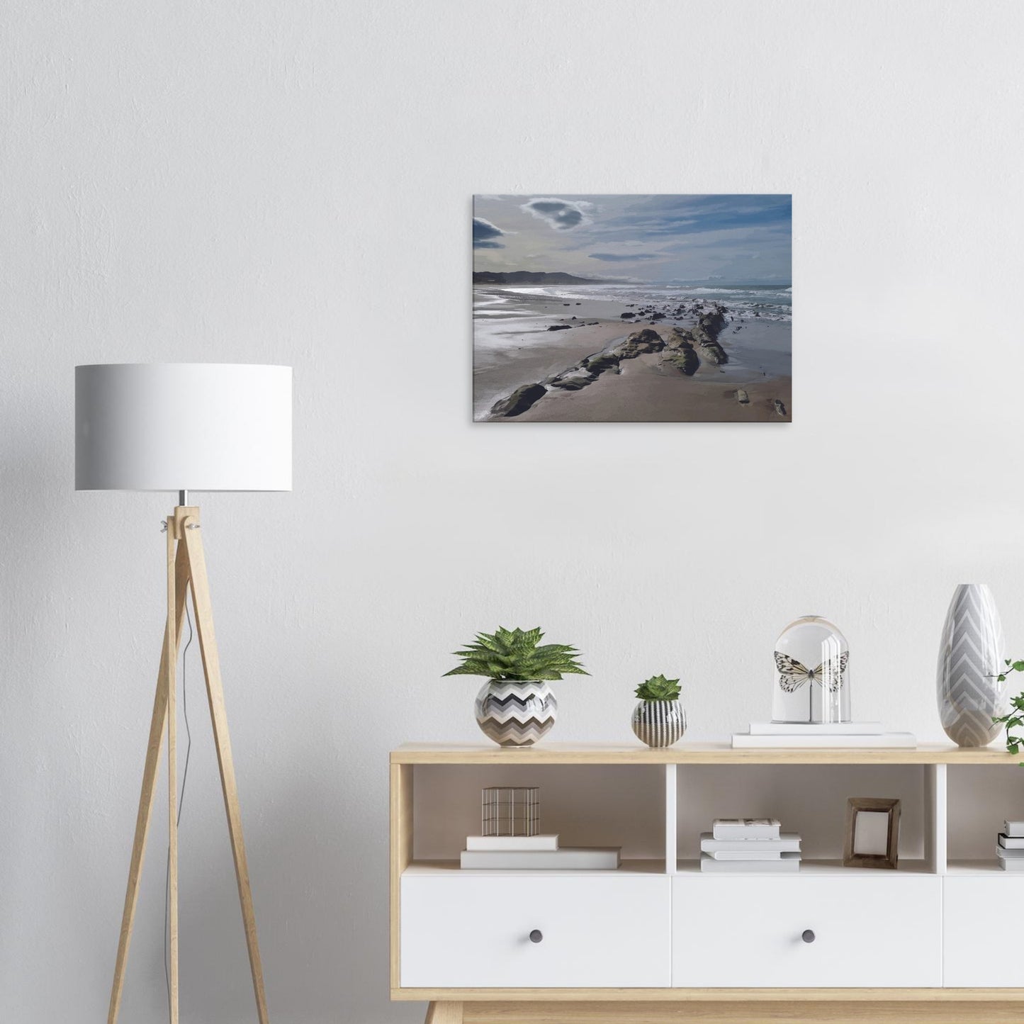 A moody, windswept beach and a line of sea-weathered rocks stretching into the distance, this artwork captures the raw, untouched feel of a wild shoreline.