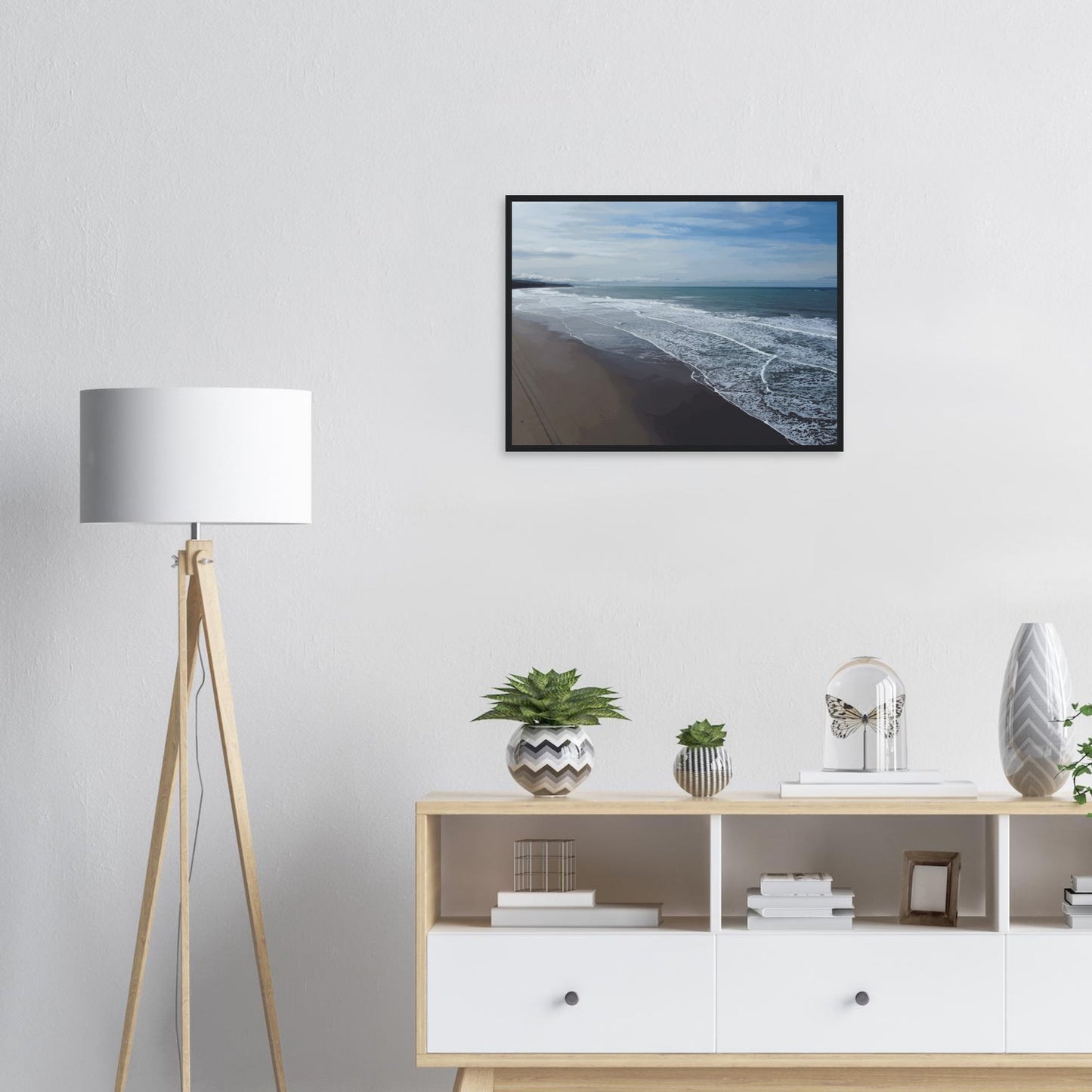 Soft, muted tones of sand, seafoam, and sky blend together in a calming composition, highlighting the natural rhythm of waves lapping the shore.