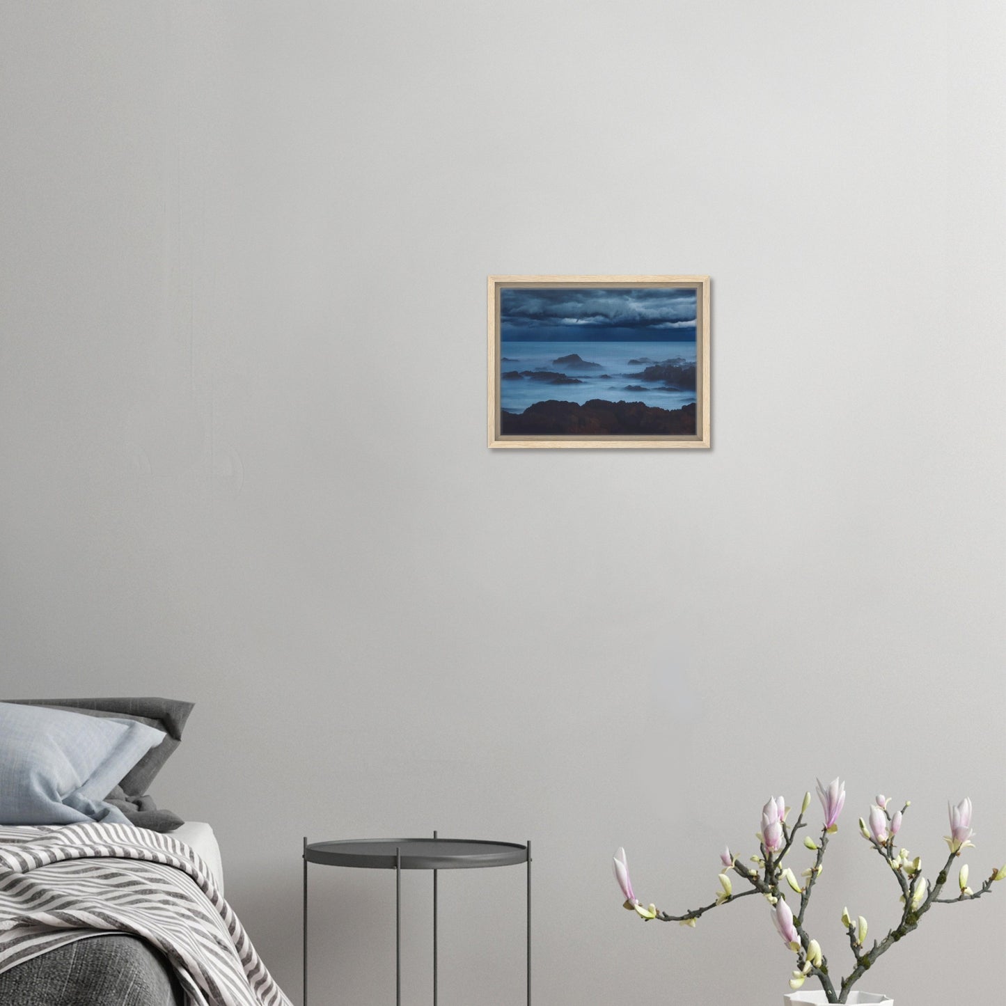 Deep navy and steel-blue tones sweep across a moody sky, while waves crash and swirl around jagged rocks, softened by a misty, dreamlike haze.