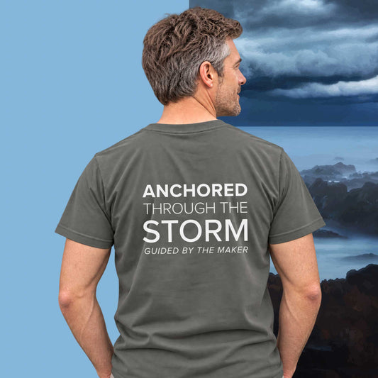 Model wearing the 'Anchored through the storm' back print tee in charcoal, large message printed on the back - Blend Designs NZ