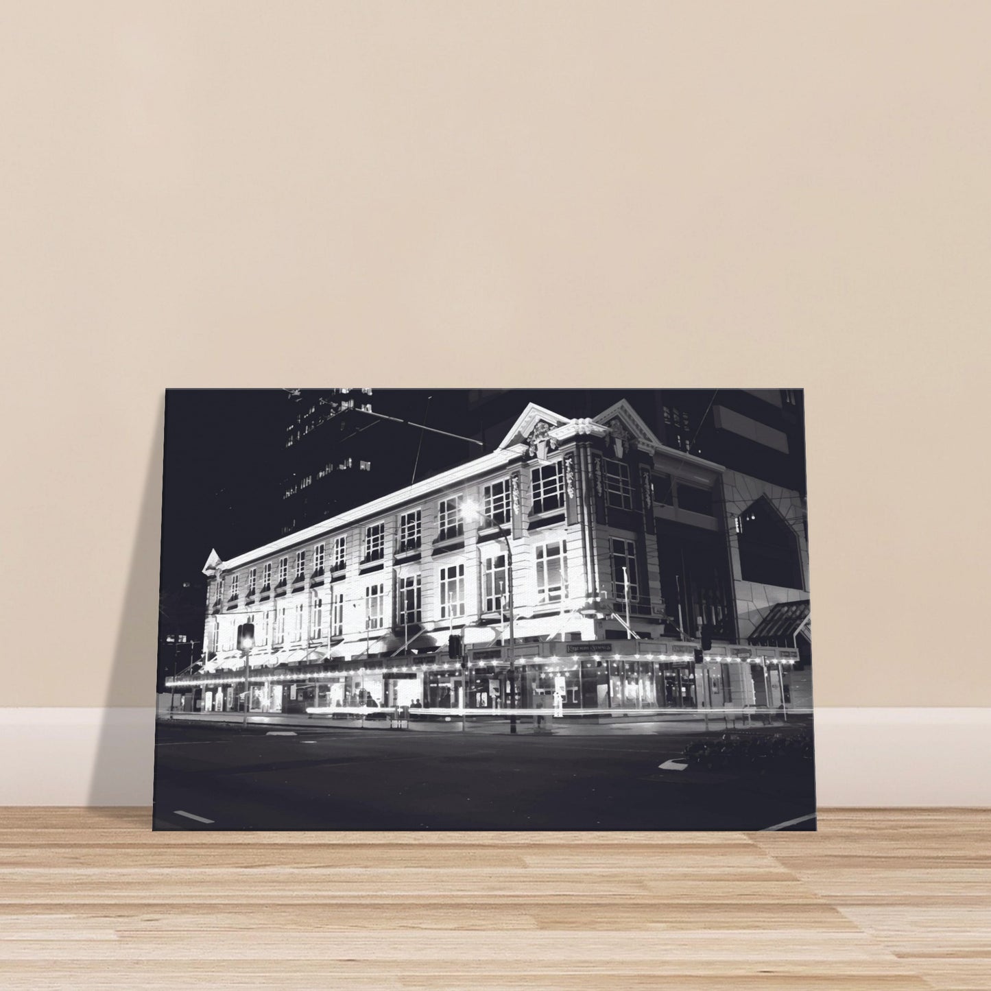 Monochrome artwork of Wellington’s Kirkaldie and Stains building lit at night, showcasing historic architectural details.