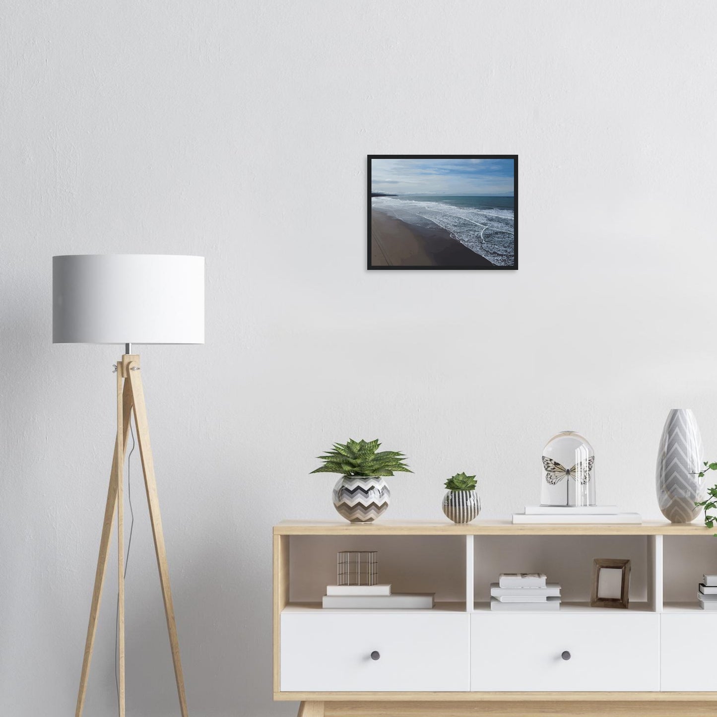 Soft, muted tones of sand, seafoam, and sky blend together in a calming composition, highlighting the natural rhythm of waves lapping the shore.