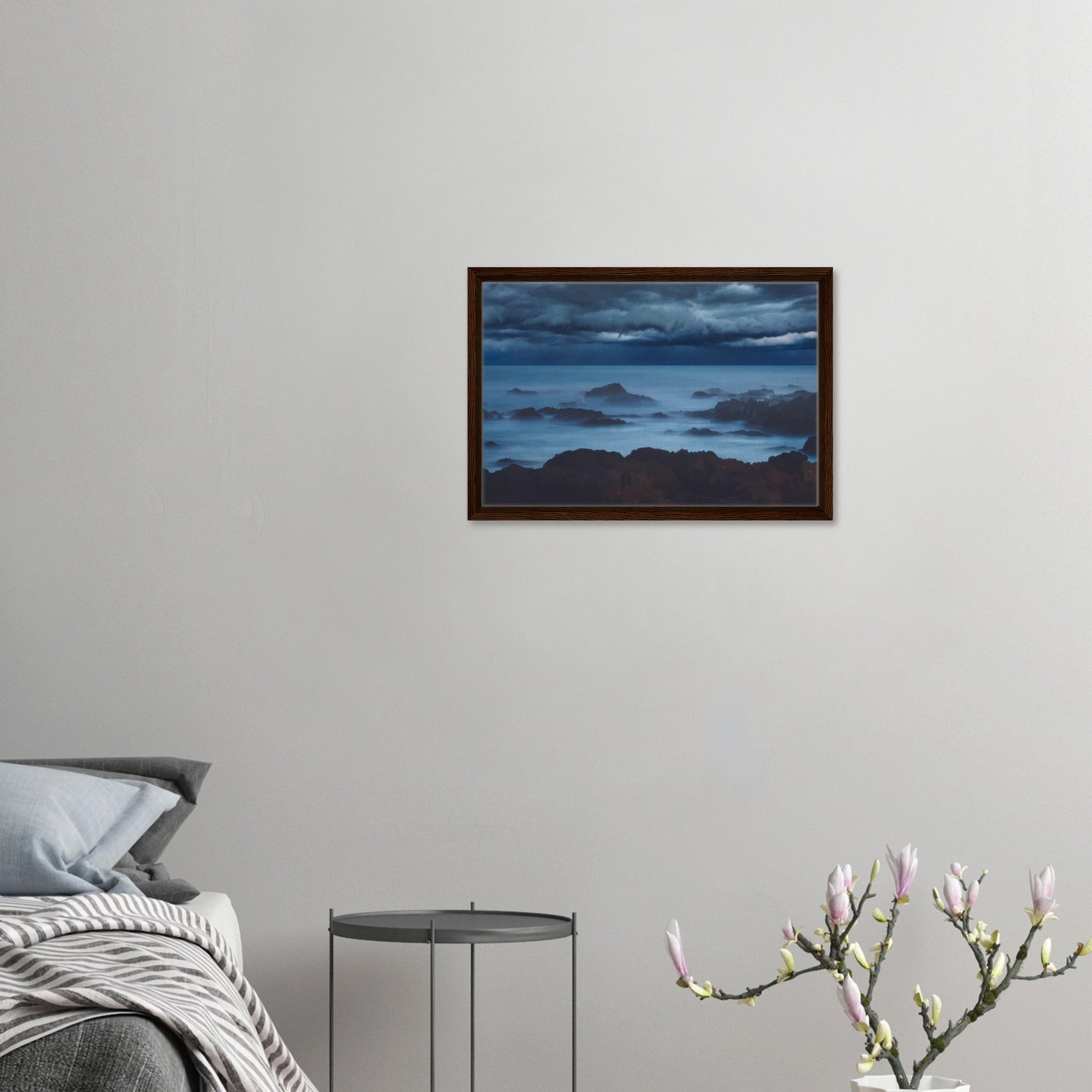 Deep navy and steel-blue tones sweep across a moody sky, while waves crash and swirl around jagged rocks, softened by a misty, dreamlike haze.