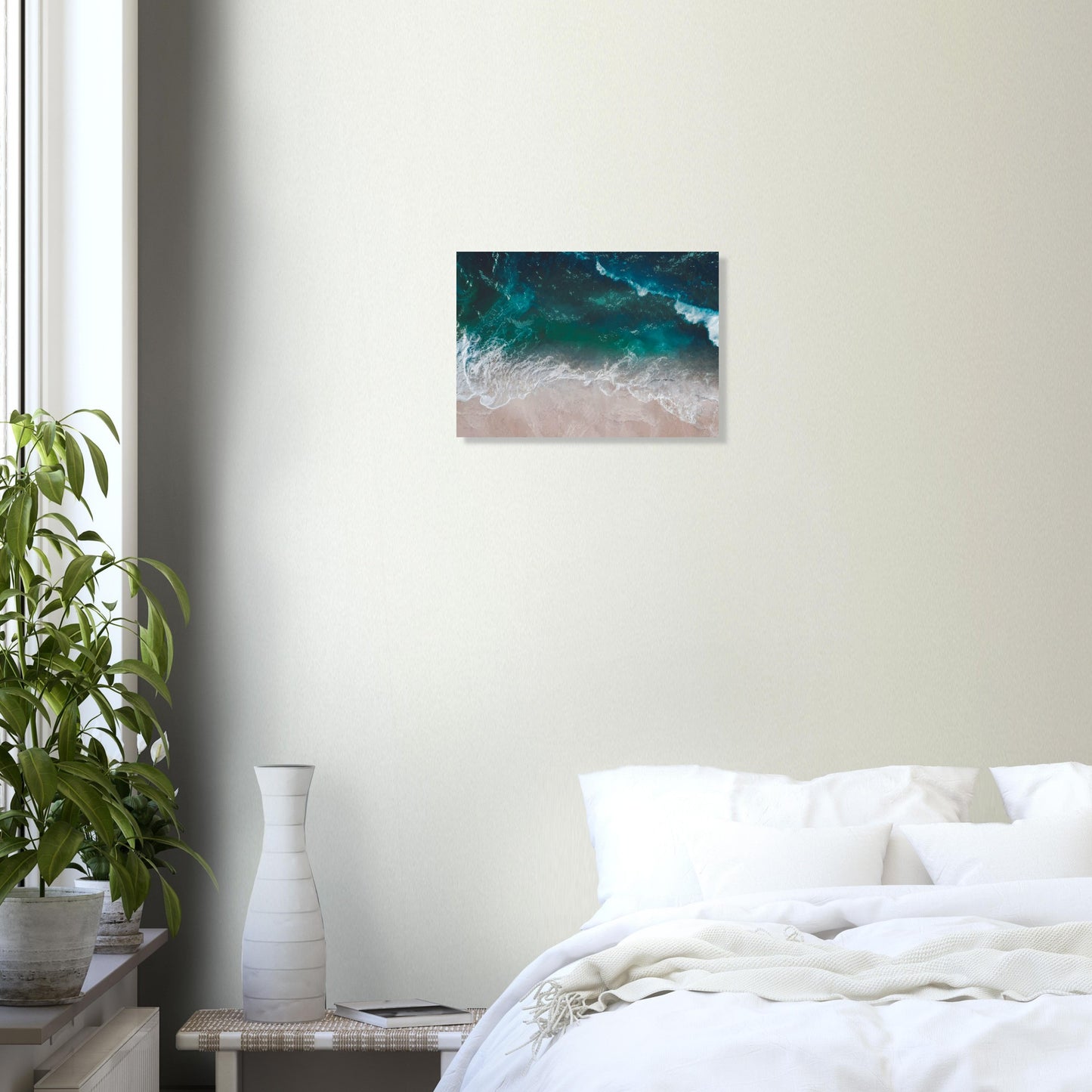 Aerial view of ocean waves rolling onto sand in teal and blue tones.