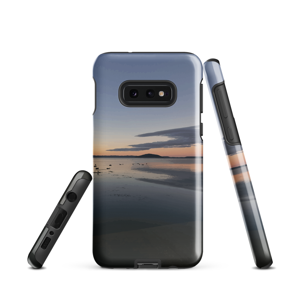 Phone case with tranquil lake scene at sunrise and distant hills.