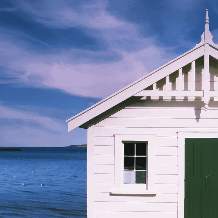 White boat shed by the sea under a blue sky in Eastbourne, New Zealand – bright and coastal.