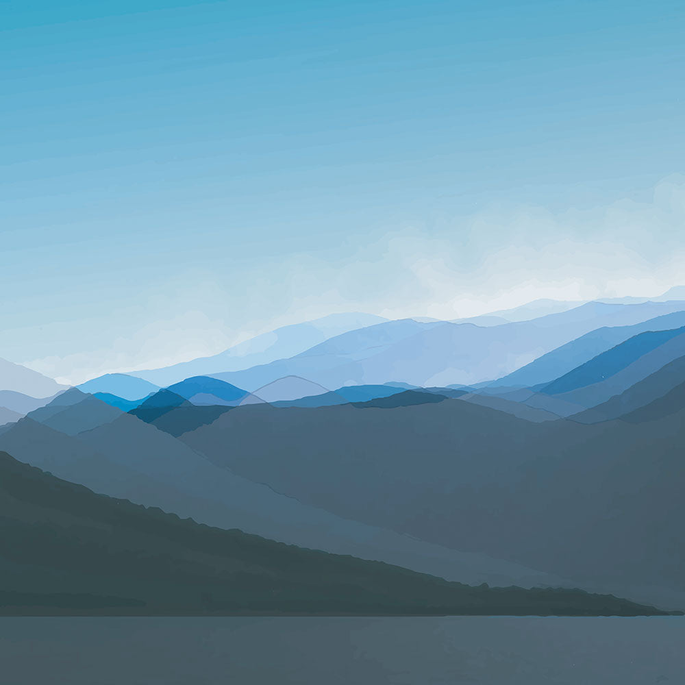 Layered blue mountain ridges fading into mist under a soft sky, evoking calm and simplicity.