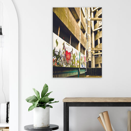 Graffiti-covered alley with concrete walls and fence, full of urban texture and raw colour.