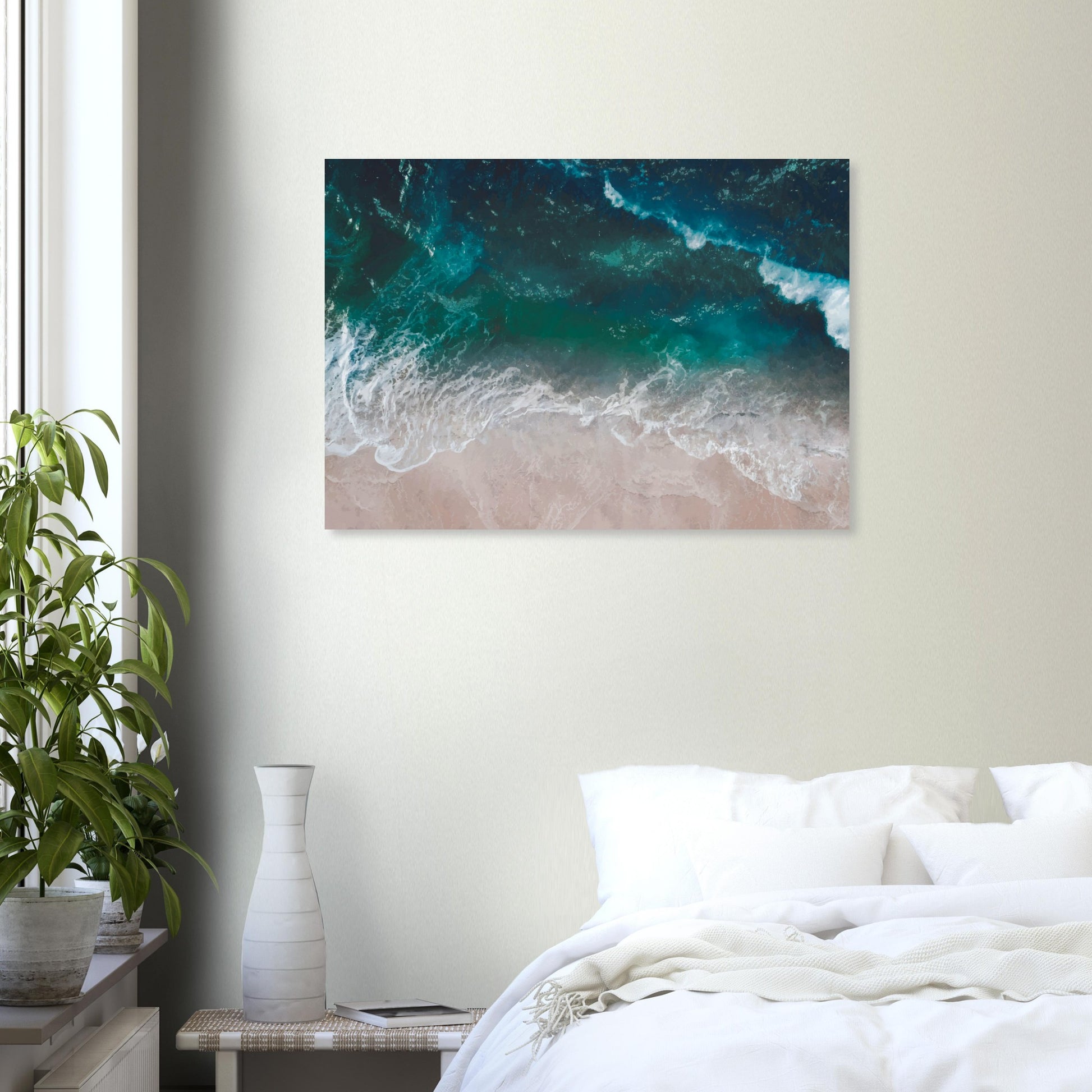 Aerial view of ocean waves rolling onto sand in teal and blue tones.