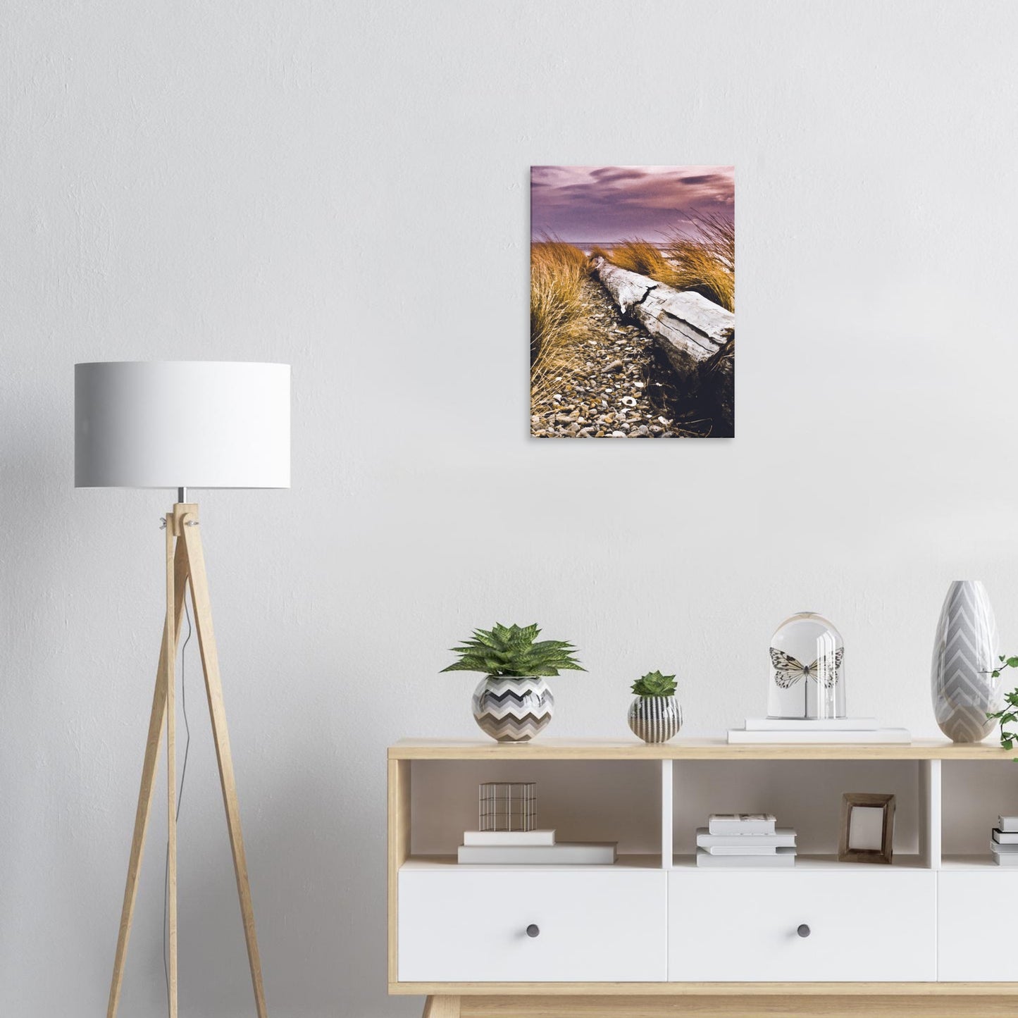 Driftwood lying in coastal grasses under a purple sky, evoking weathered texture and calm.