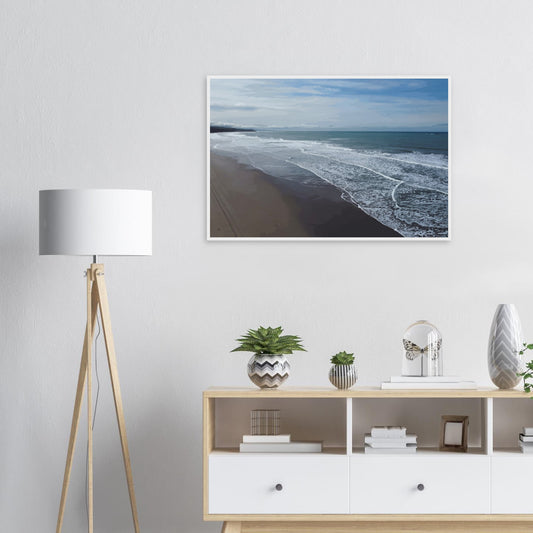 Soft, muted tones of sand, seafoam, and sky blend together in a calming composition, highlighting the natural rhythm of waves lapping the shore.