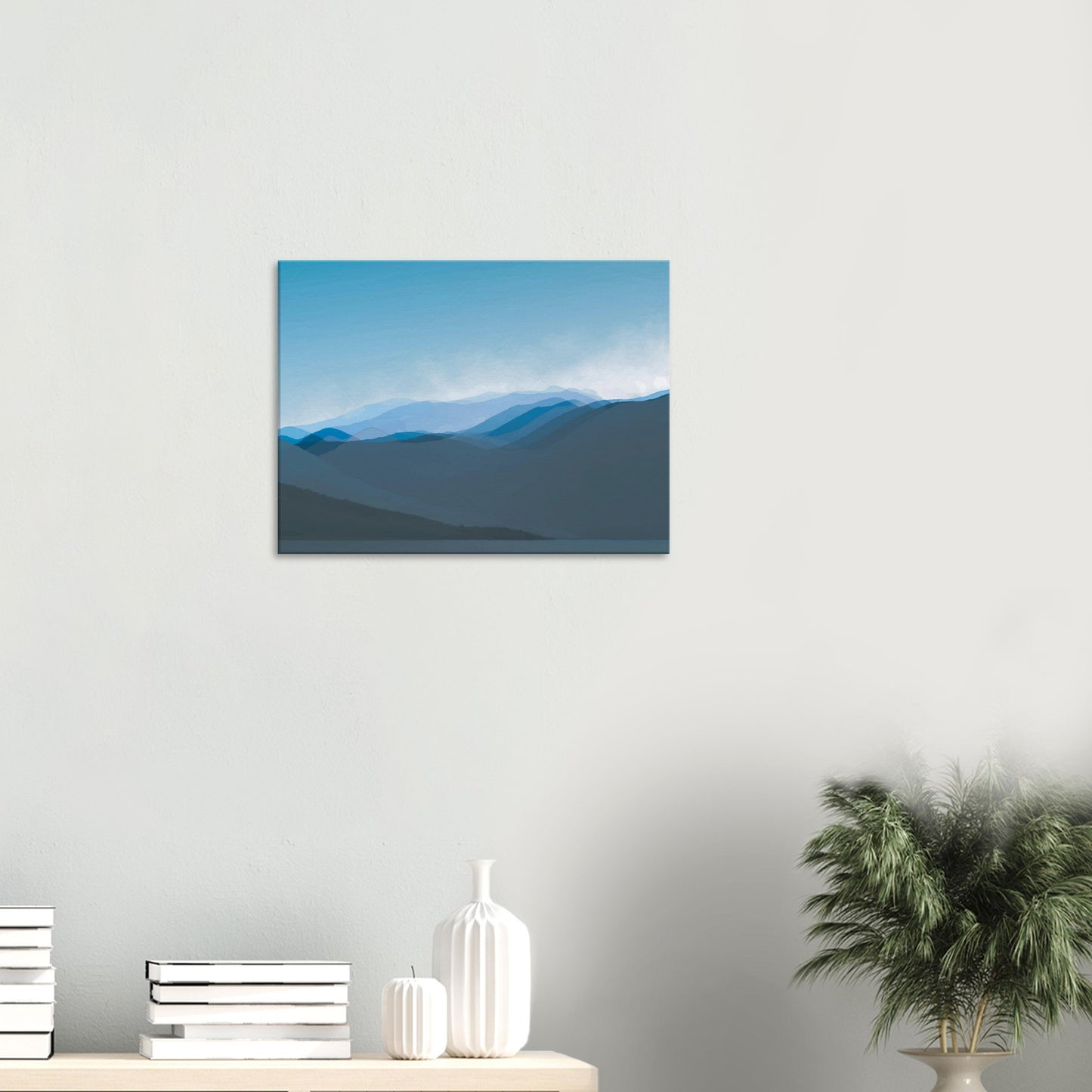 Layered blue mountain ridges fading into mist under a soft sky, evoking calm and simplicity.