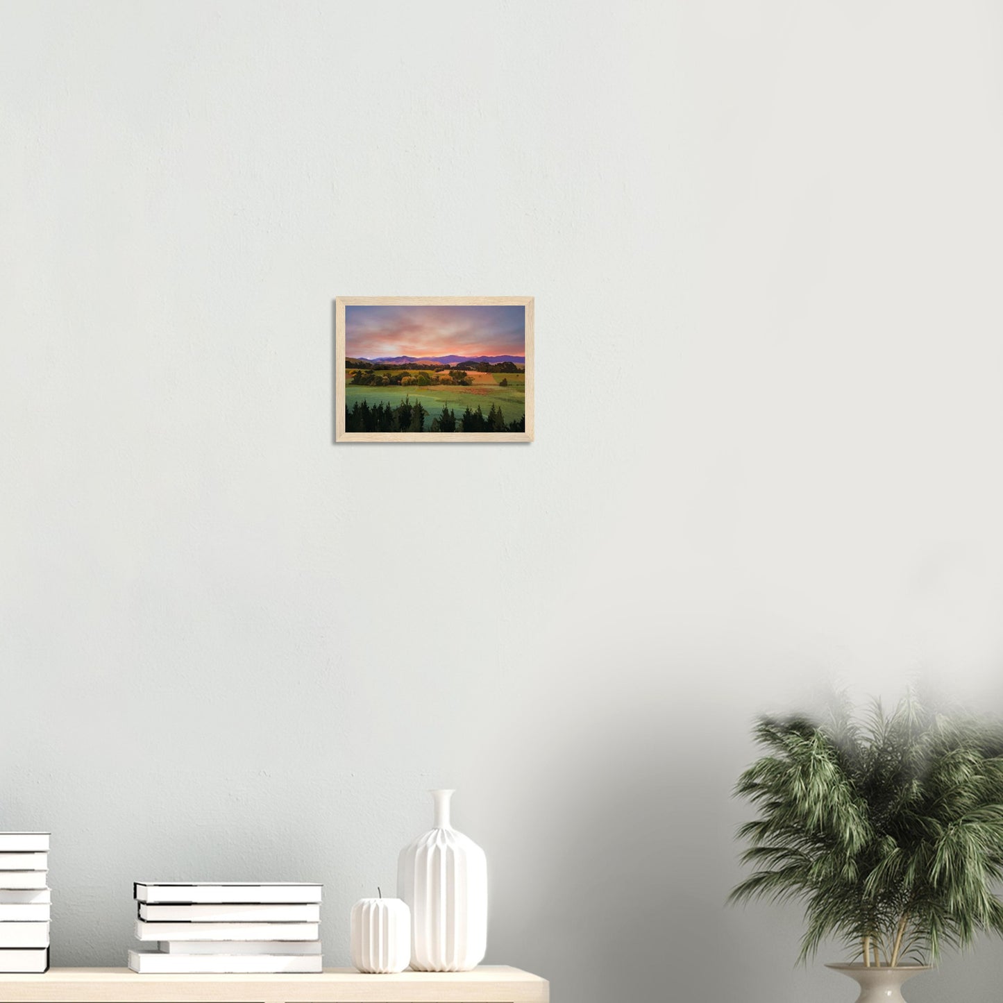 Artwork of a Wairarapa sunrise over pine trees and rolling farmland with soft light on the Tararua Ranges.