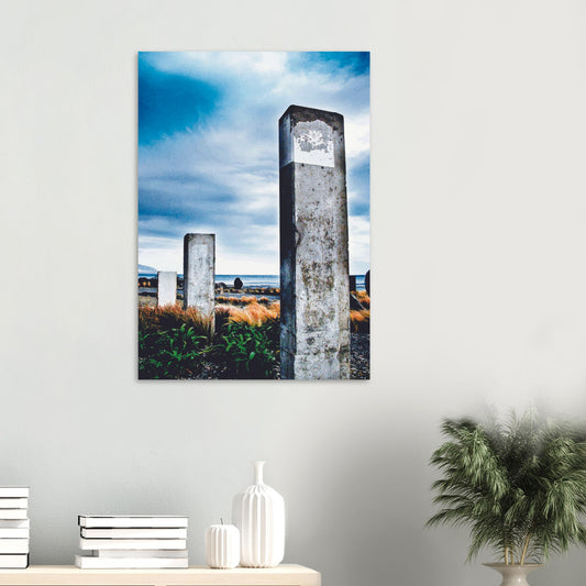 Concrete pillars on the Wellington coast at Owhiro Bay with grasses, sea, and moody sky.