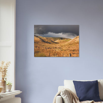Golden Hawke’s Bay hills beneath dark clouds in a nostalgic NZ landscape artwork titled Trip Home by Ben Hart.