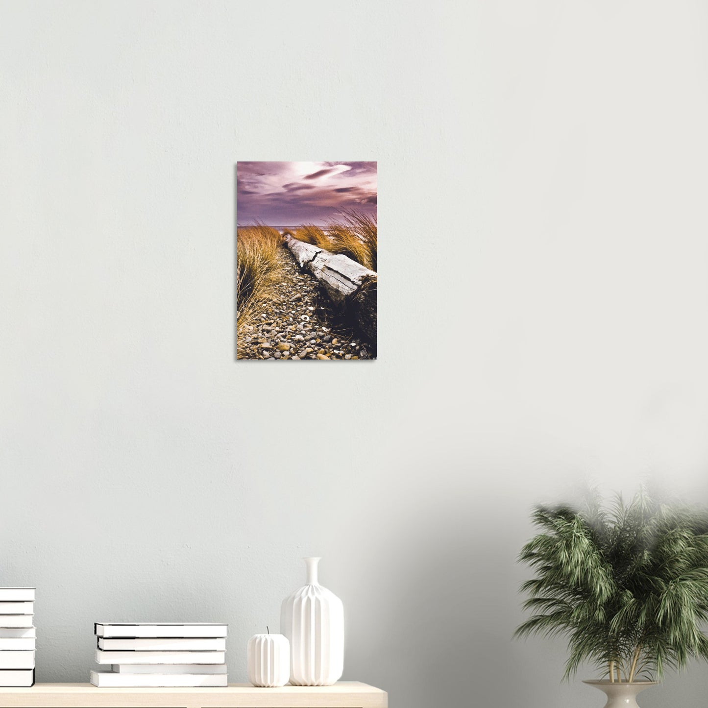 Driftwood lying in coastal grasses under a purple sky, evoking weathered texture and calm.