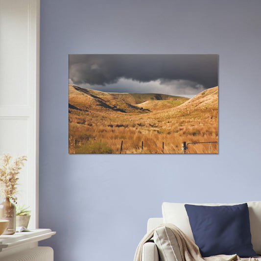 Golden Hawke’s Bay hills beneath dark clouds in a nostalgic NZ landscape artwork titled Trip Home by Ben Hart.