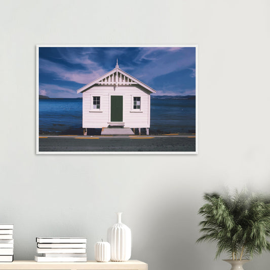 White boat shed by the sea under a blue sky in Eastbourne, New Zealand – bright and coastal.