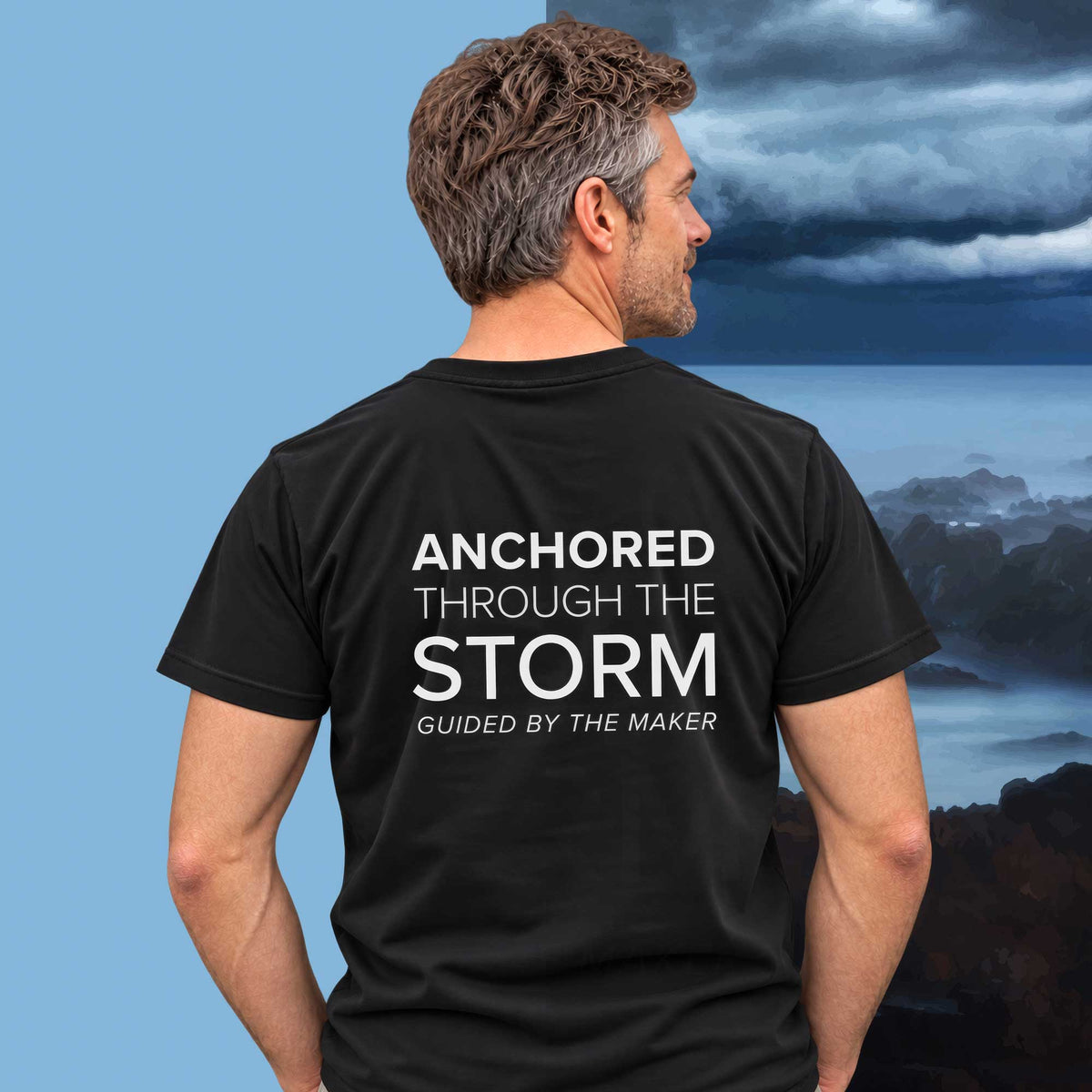 Model wearing the 'Anchored through the storm' back print tee in black, large message printed on the back - Blend Designs NZ