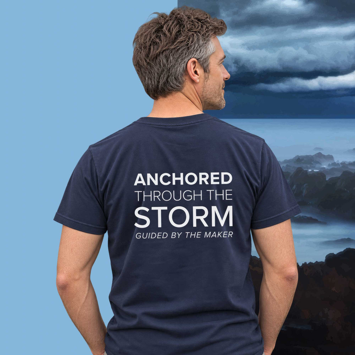 Model wearing the 'Anchored through the storm' back print tee in navy, large message printed on the back - Blend Designs NZ