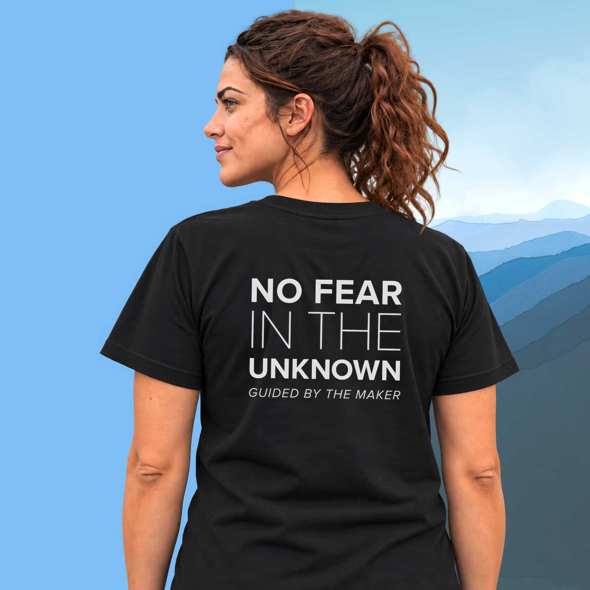 Model wearing the 'No fear in the unknown' back print tee in black, large message printed on the back - Blend Designs NZ