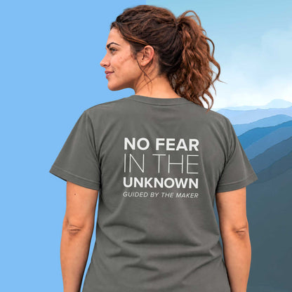 Model wearing the 'No fear in the unknown' back print tee in charcoal, large message printed on the back - Blend Designs NZ