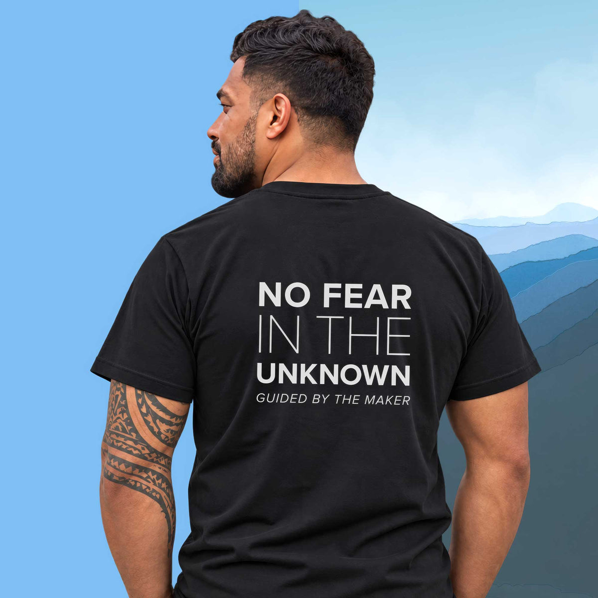 Model wearing the 'No fear in the unknown' back print tee in black, large message printed on the back - Blend Designs NZ