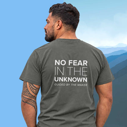 Model wearing the 'No fear in the unknown' back print tee in charcoal, large message printed on the back - Blend Designs NZ