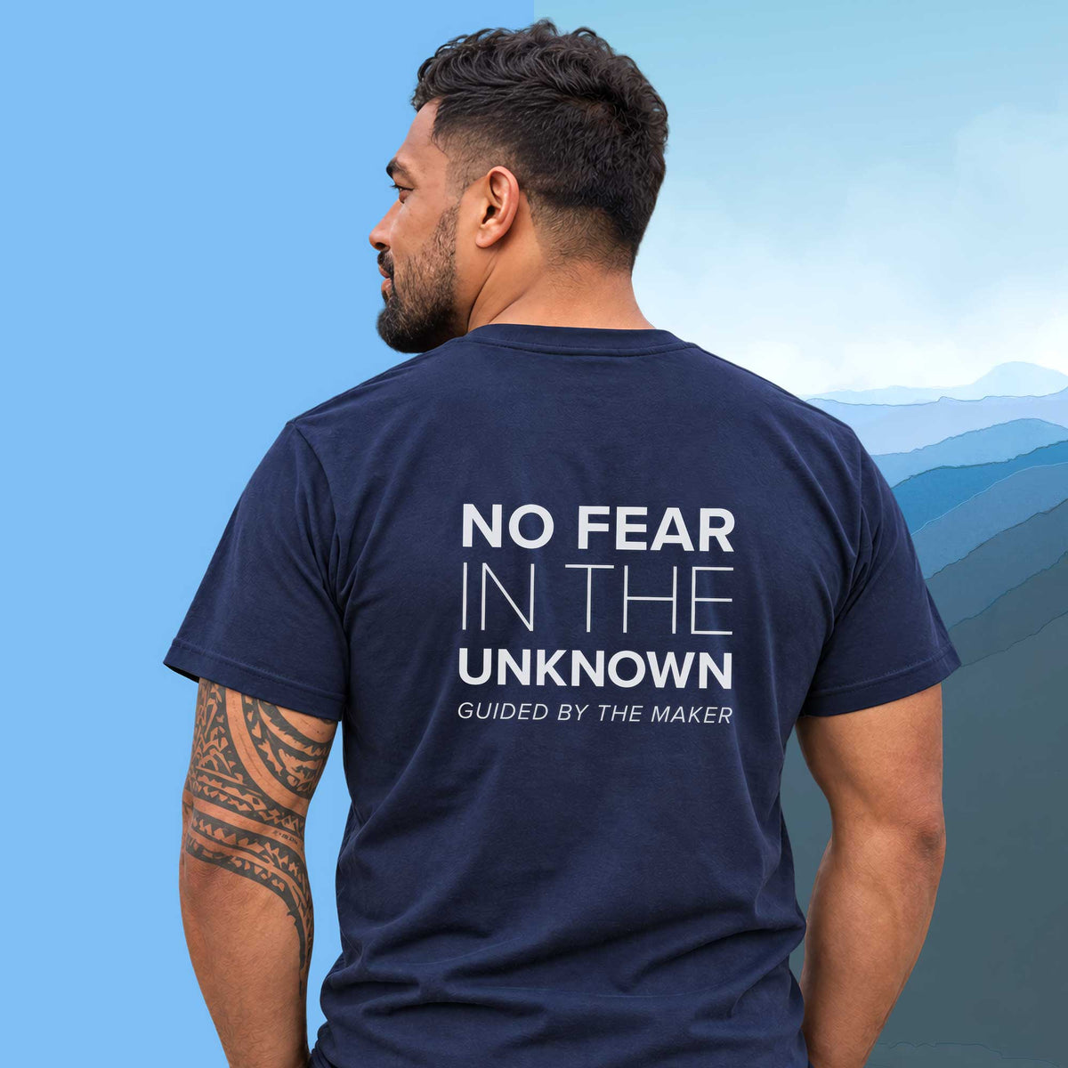 Model wearing the 'No fear in the unknown' back print tee in navy, large message printed on the back - Blend Designs NZ