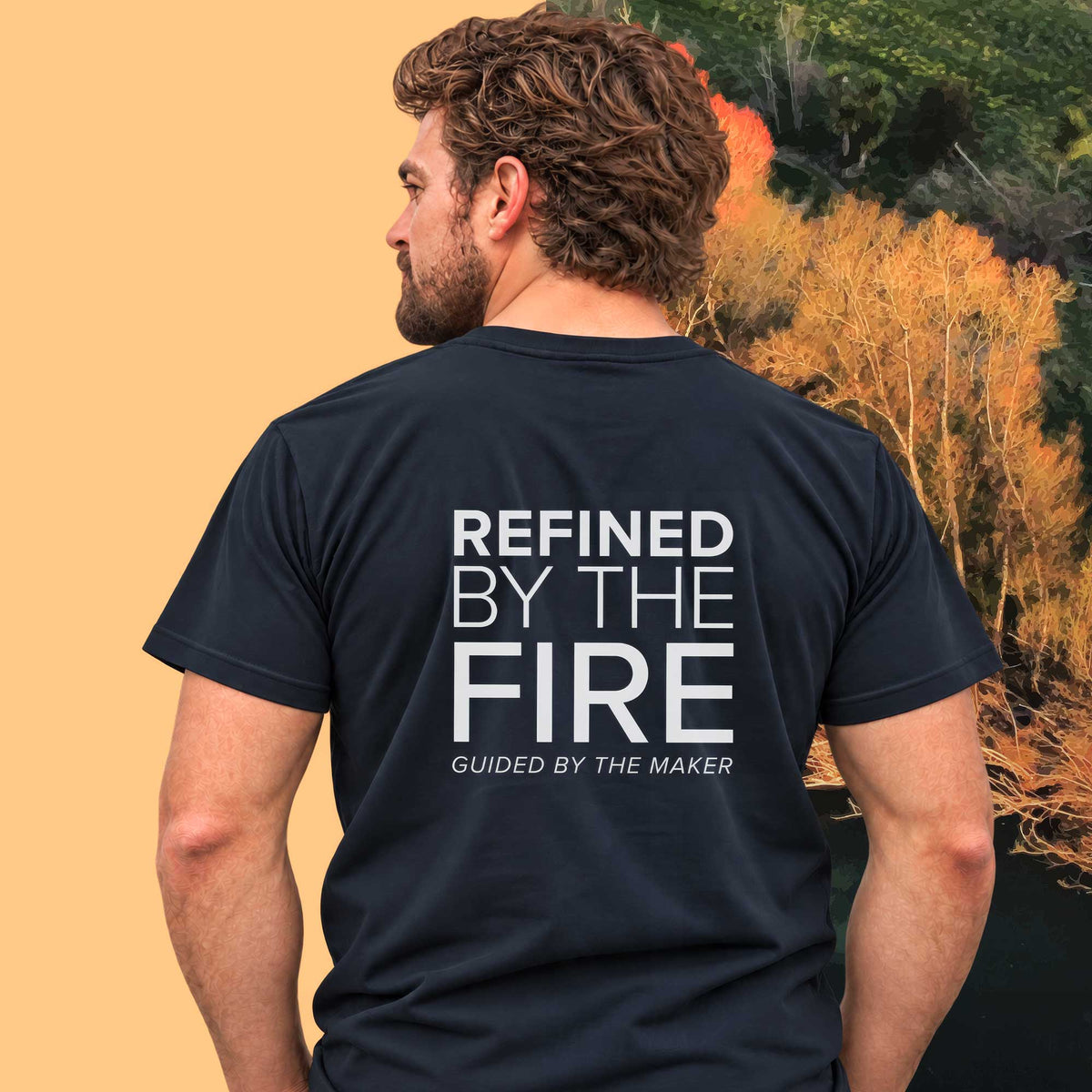 Model wearing the 'Refined by the fire' back print tee in navy, large message printed on the back - Blend Designs NZ