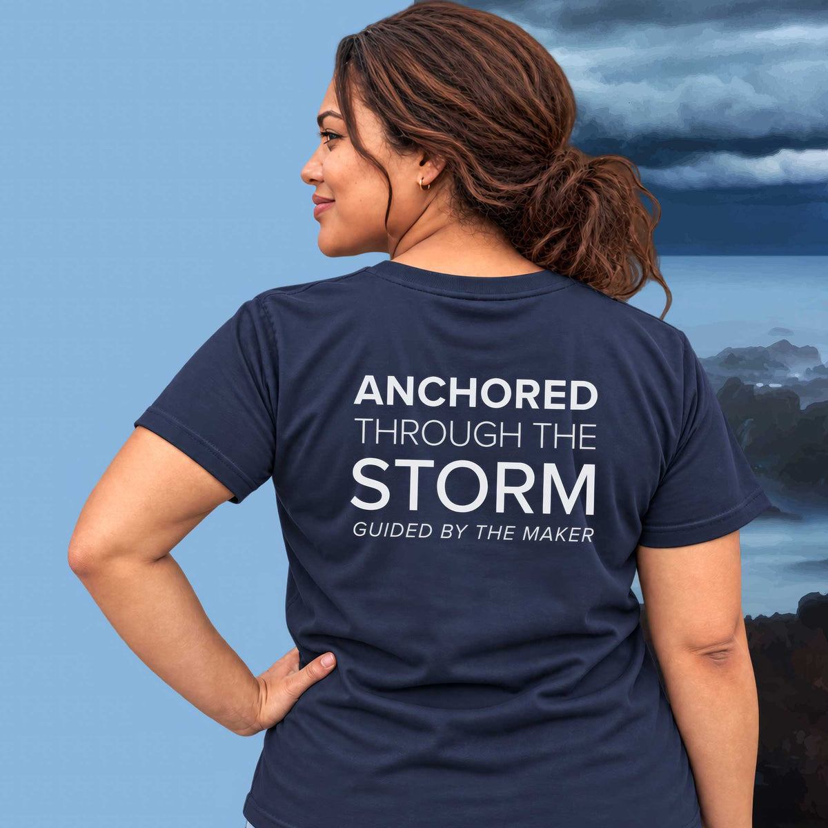 Model wearing the 'Anchored through the storm' back print tee in navy, large message printed on the back - Blend Designs NZ