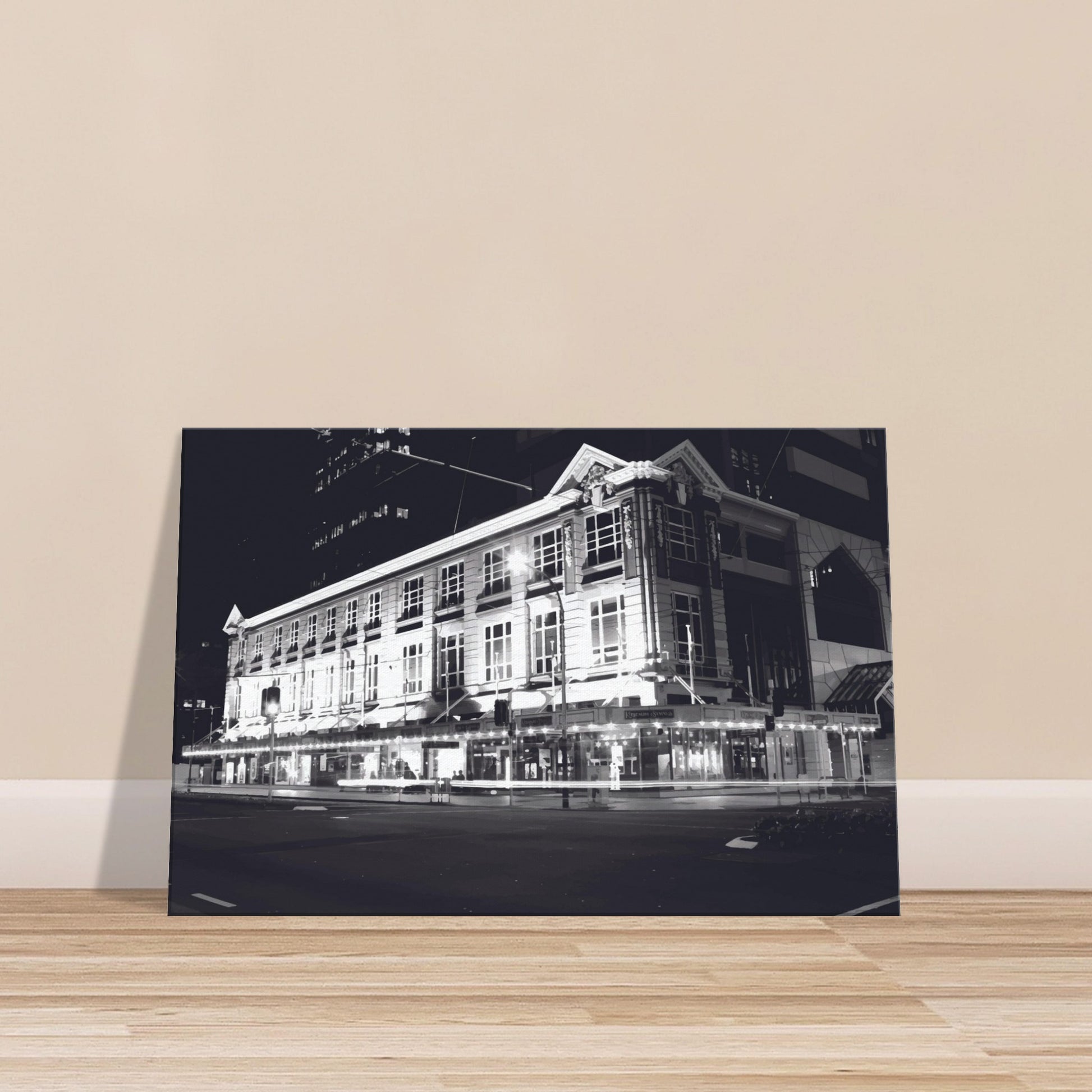 Monochrome artwork of Wellington’s Kirkaldie and Stains building lit at night, showcasing historic architectural details.