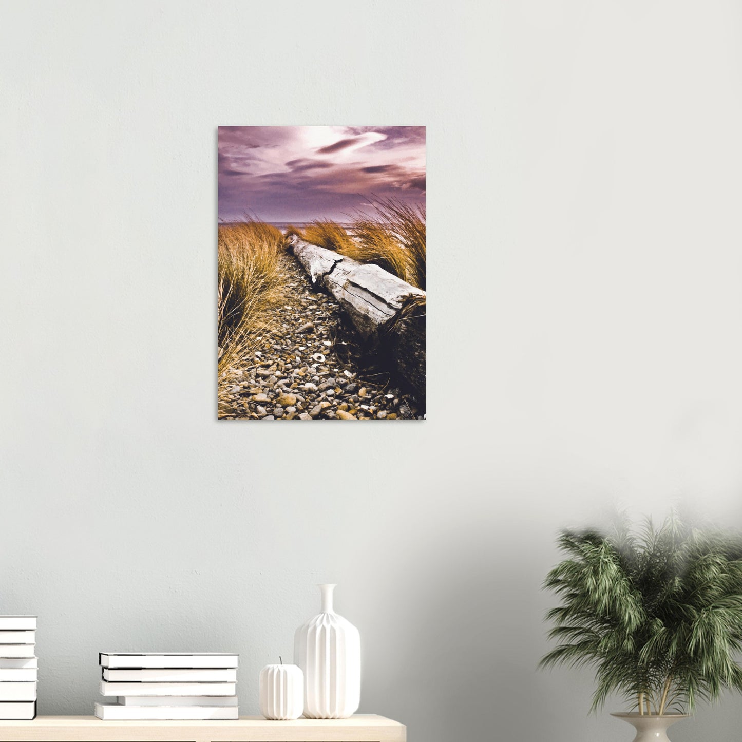 Driftwood lying in coastal grasses under a purple sky, evoking weathered texture and calm.