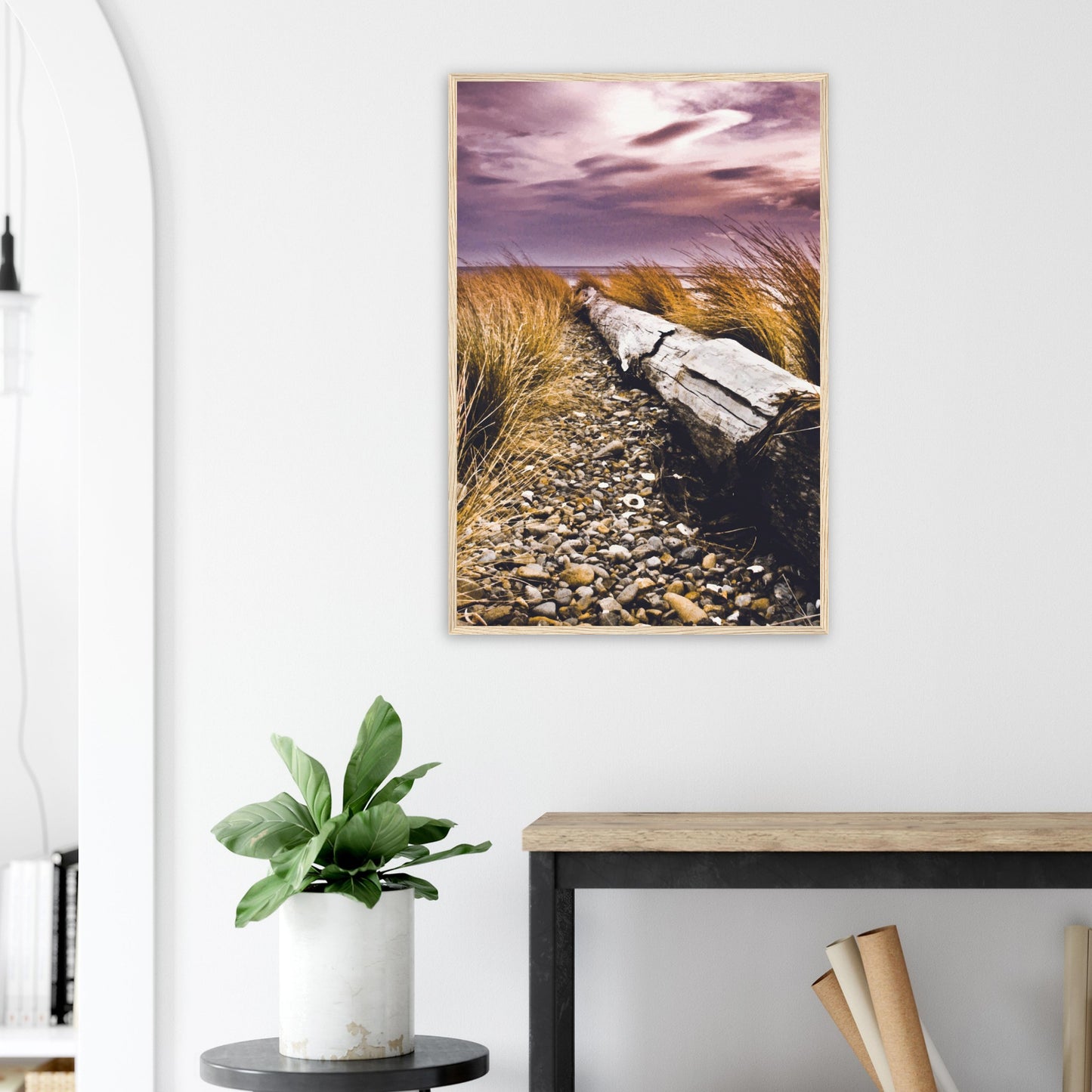 Driftwood lying in coastal grasses under a purple sky, evoking weathered texture and calm.