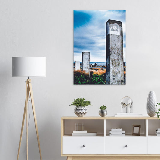 Concrete pillars on the Wellington coast at Owhiro Bay with grasses, sea, and moody sky.