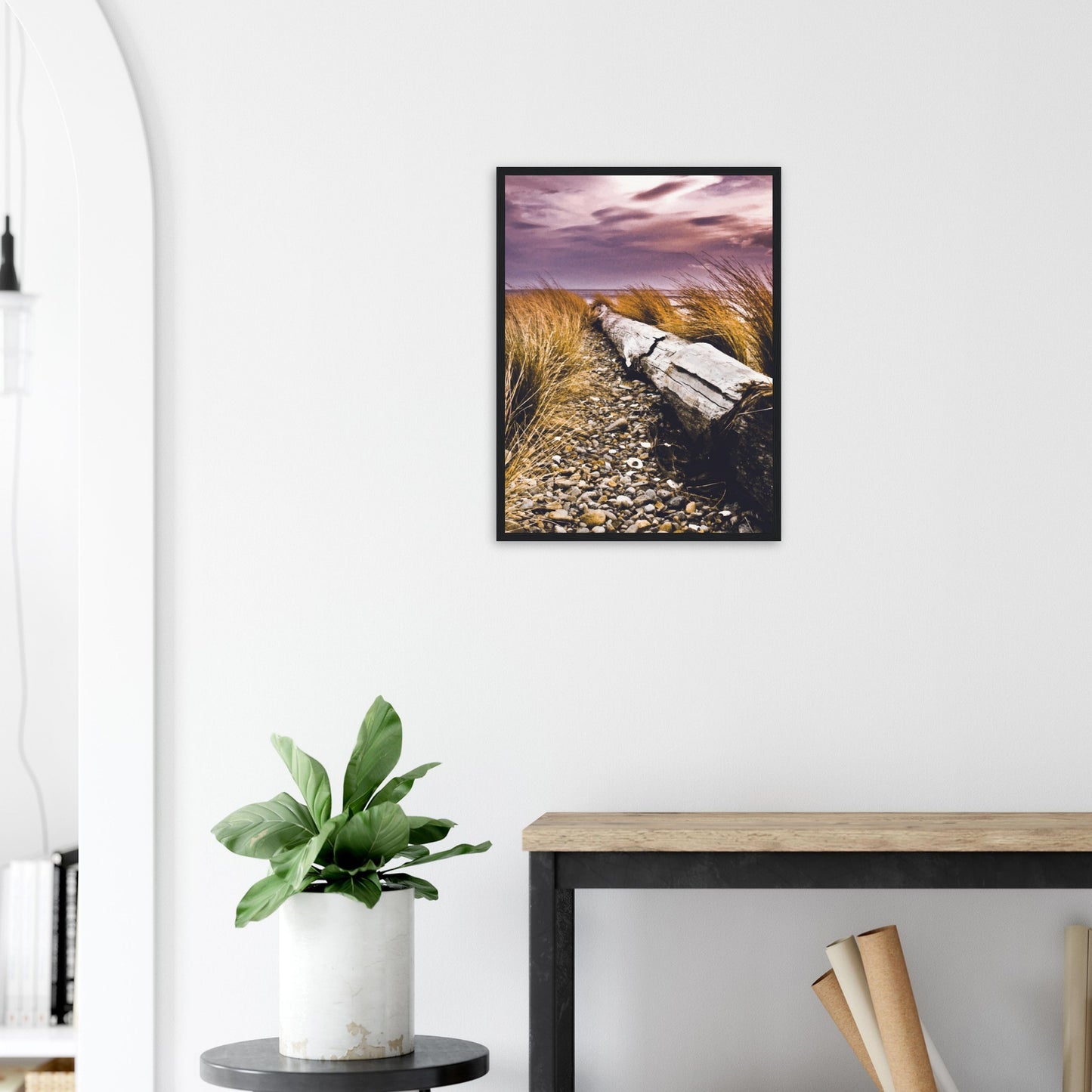 Driftwood lying in coastal grasses under a purple sky, evoking weathered texture and calm.