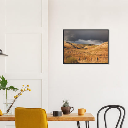 Golden Hawke’s Bay hills beneath dark clouds in a nostalgic NZ landscape artwork titled Trip Home by Ben Hart.