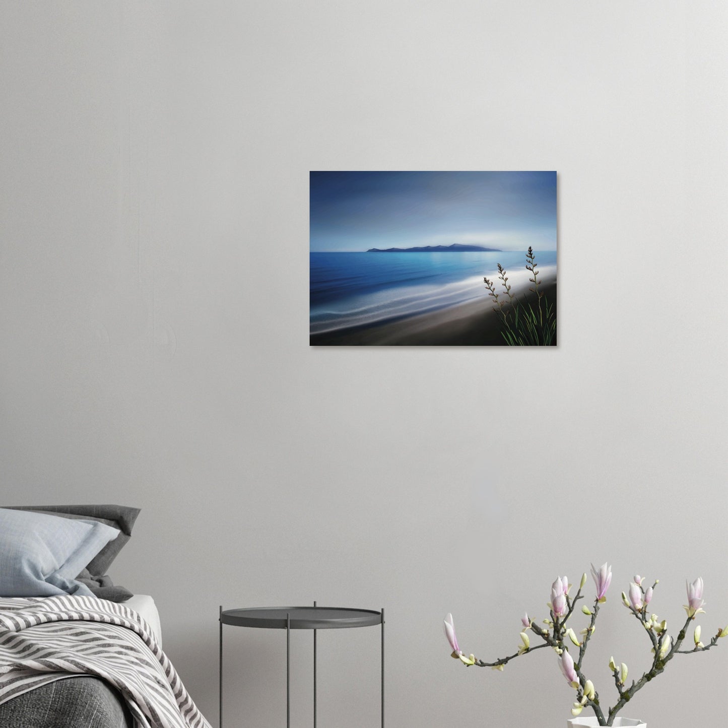 Kapiti Island with soft blue sea, gentle waves and native flax in the foreground.