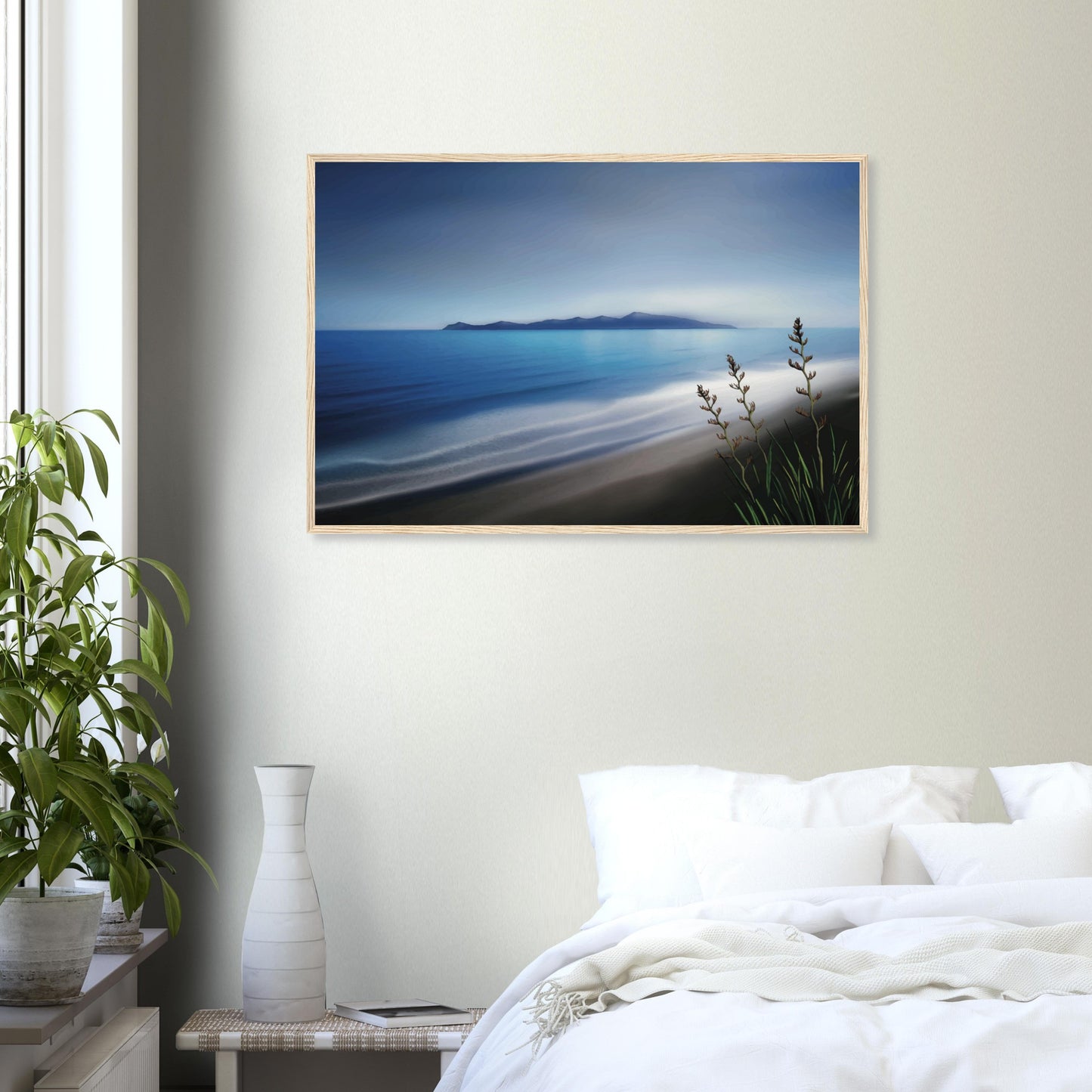 Kapiti Island with soft blue sea, gentle waves and native flax in the foreground.