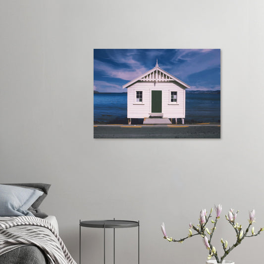 White boat shed by the sea under a blue sky in Eastbourne, New Zealand – bright and coastal.