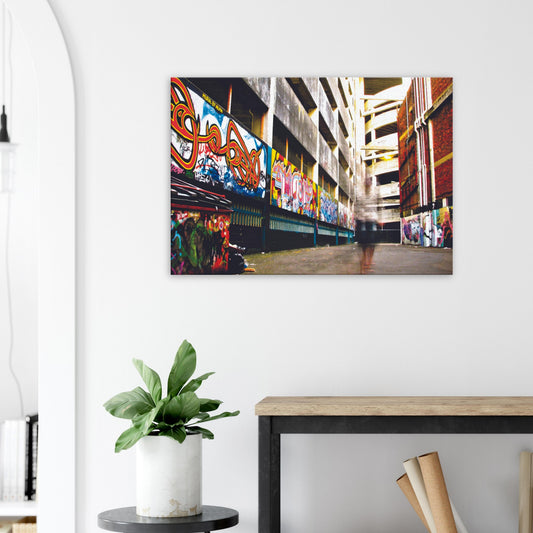 Ghost-like figure walking through graffiti-lined alley in an urban scene full of colour and contrast.