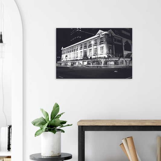 Monochrome artwork of Wellington’s Kirkaldie and Stains building lit at night, showcasing historic architectural details.